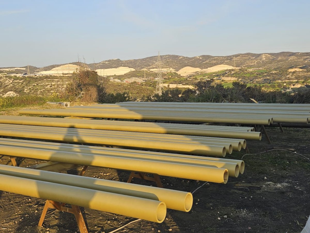 Industrial pipes painted yellow/olive, ready for installation on Cyprus site